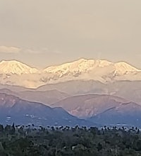 a mountain range with snow capped mountains in the background